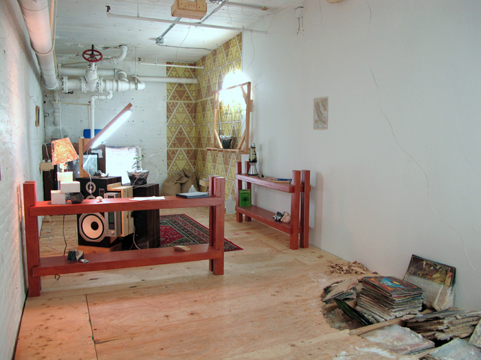 A room with shelves, speakers, a red rug, grow lights, strange lamps, and records growing out of the floor.