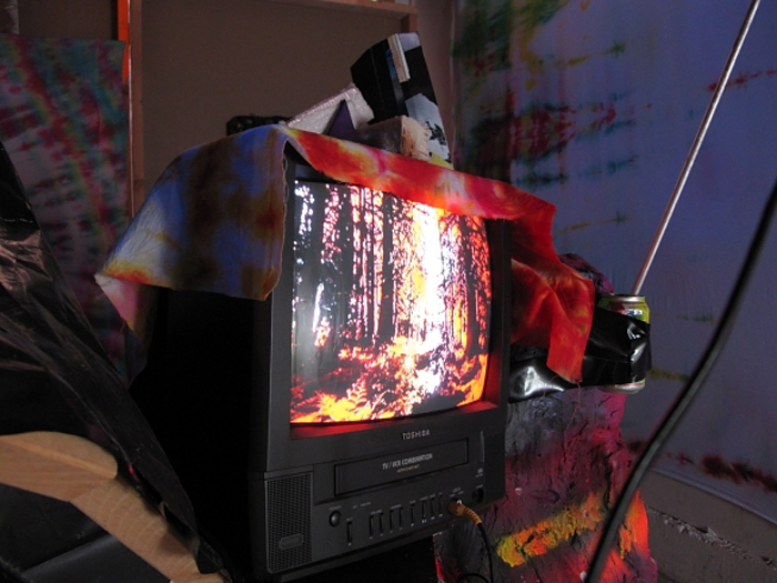 A television with an image resembling a tie-dyed forest