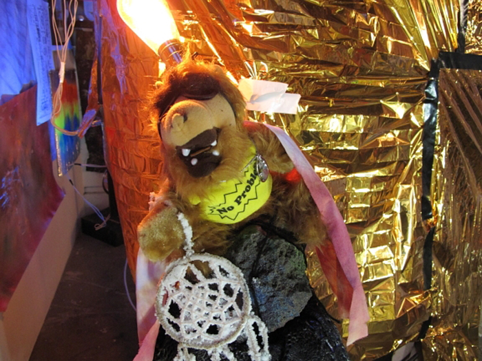 A figure of Alf with a lightbulb coming out of its head and a crystalized dream catcher.